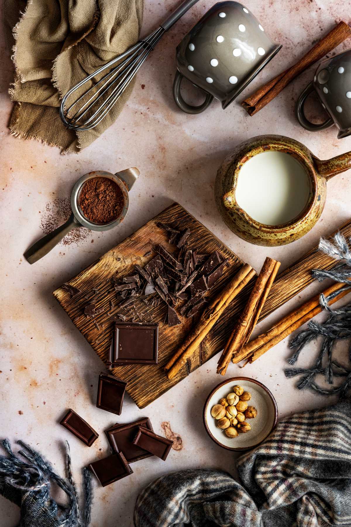dark chocolate, hazelnuts, hazelnut milk, cocoa powder and cinnamon on a table