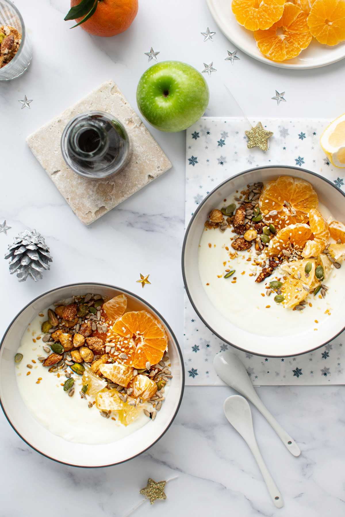 vegan yogurt bowls with nuts and orange on a table