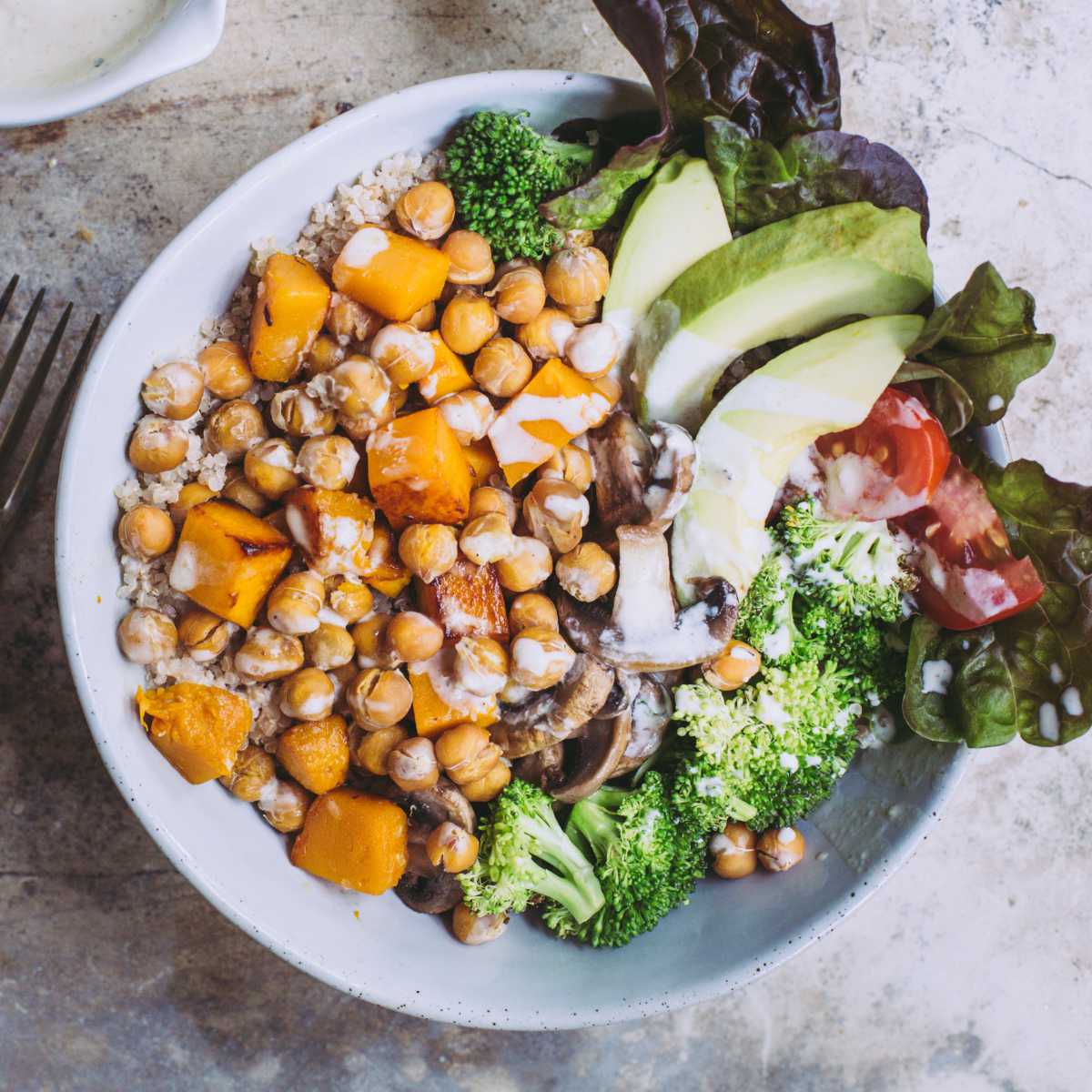 vegan protein bowl with chickpeas, quinoa, veggies and dressing